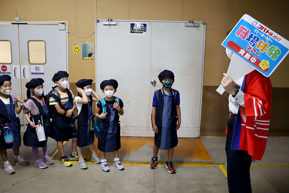 バックヤードを案内される子どもたちの画像
